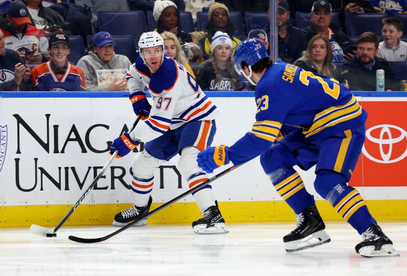 Nov 17, 2025; Buffalo, New York, USA;  Edmonton Oilers center Connor McDavid (97) looks to make a pass as Buffalo Sabres defenseman Mattias Samuelsson (23) defends during the first period at KeyBank Center. Mandatory Credit: Timothy T. Ludwig-Imagn Images