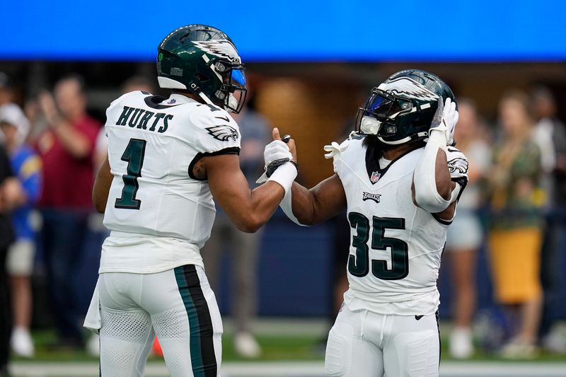 Philadelphia Eagles quarterback Jalen Hurts, left, and running back Boston Scott shake hands as they warm up prior to an NFL football game against the Los Angeles Rams Sunday, Oct. 8, 2023, in Inglewood, Calif. (AP Photo/Gregory Bull)