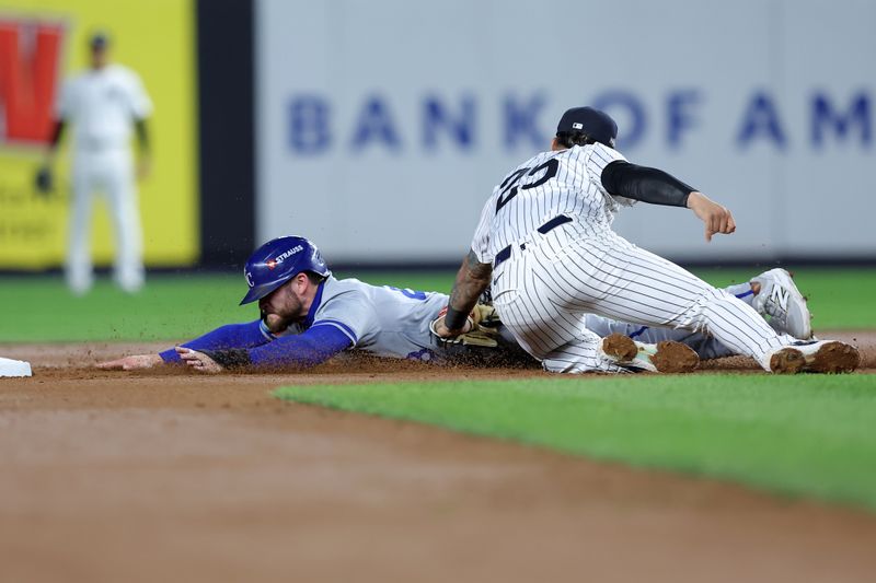 Oct 7, 2024; Bronx, New York, USA; New York Yankees second base Gleyber Torres (25) tags out Kansas City Royals outfielder Kyle Isbel (28) attempt to steal second base in the seventh inning during game two of the ALDS for the 2024 MLB Playoffs at Yankee Stadium. Mandatory Credit: Brad Penner-Imagn Images