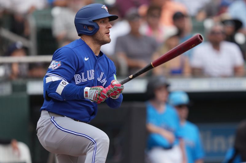 Mar 16, 2026; Jupiter, Florida, USA;  Toronto Blue Jays center fielder Daulton Varsho (5) hits a double that scores two runs in the third inning against the Miami Marlins at Roger Dean Chevrolet Stadium. Mandatory Credit: Jim Rassol-Imagn Images