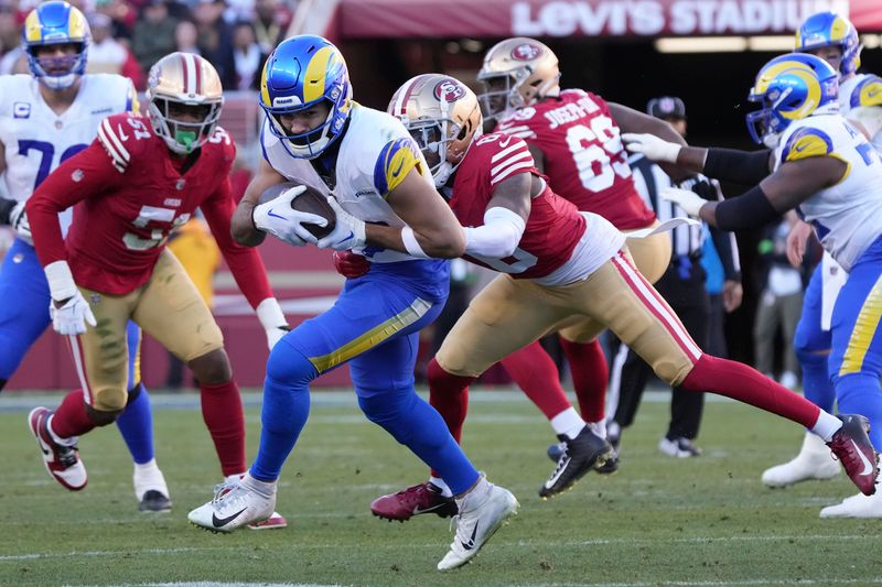 Los Angeles Rams wide receiver Puka Nacua, middle left, runs after catching a pass against the San Francisco 49ers during the second half of an NFL football game in Santa Clara, Calif., Sunday, Jan. 7, 2024. Nacua set a rookie record for receiving yards on this play. (AP Photo/Loren Elliott)