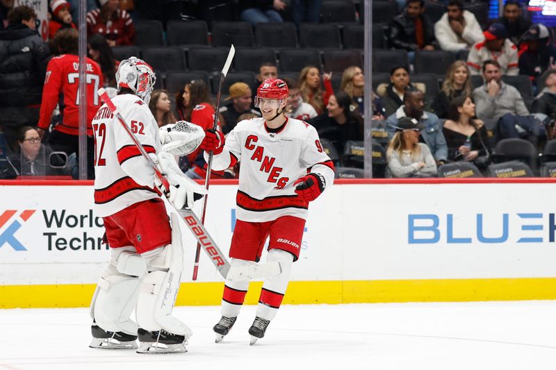 Jan 5, 2024; Washington, District of Columbia, USA; Carolina Hurricanes center Vasiliy Ponomarev (92) celebrates with Hurricanes goaltender Pyotr Kochetkov (52) after scoring a goal in his NHL debut against the Washington Capitals in the third period at Capital One Arena. Mandatory Credit: Geoff Burke-USA TODAY Sports