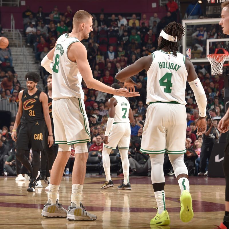 CLEVELAND, OH - MARCH 5: Kristaps Porzingis #8 and Jrue Holiday #4 of the Boston Celtics high five during the game against the Cleveland Cavaliers on March 5, 2024 at Rocket Mortgage FieldHouse in Cleveland, Ohio. NOTE TO USER: User expressly acknowledges and agrees that, by downloading and/or using this Photograph, user is consenting to the terms and conditions of the Getty Images License Agreement. Mandatory Copyright Notice: Copyright 2024 NBAE (Photo by David Liam Kyle/NBAE via Getty Images)