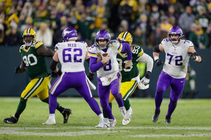 Minnesota Vikings quarterback Kirk Cousins (8) rushes past Green Bay Packers defensive tackle T.J. Slaton (93) during an NFL football game Sunday, Jan.1, 2023, in Green Bay, Wis. (AP Photo/Matt Ludtke)