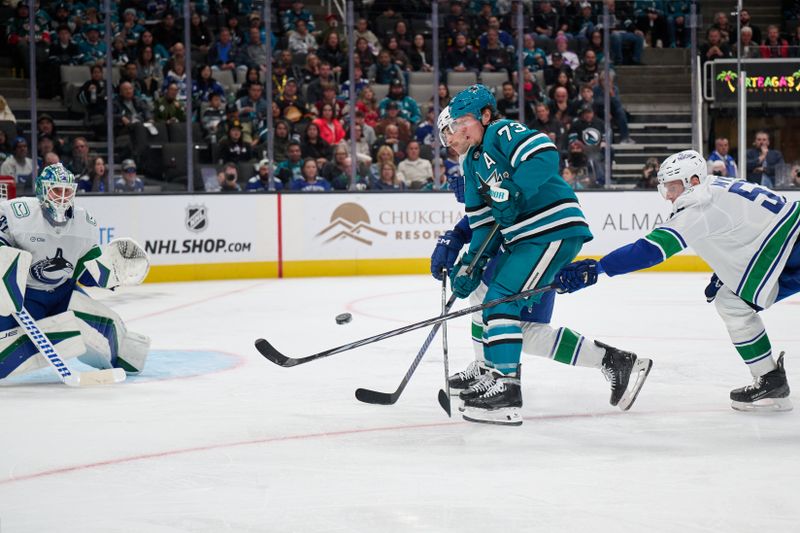 Nov 2, 2024; San Jose, California, USA; Vancouver Canucks center Teddy Blueger (53) (right) and goaltender Kevin Lankinen (32) defend the puck against San Jose Sharks right wing Tyler Toffoli (73) during the second period at SAP Center at San Jose. Mandatory Credit: Robert Edwards-Imagn Images