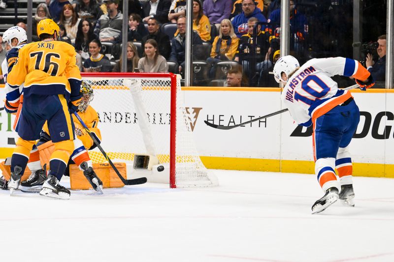 Jan 8, 2026; Nashville, Tennessee, USA; New York Islanders right wing Simon Holmstrom (10) scores a goal past Nashville Predators goaltender Juuse Saros (74) during the second period at Bridgestone Arena. Mandatory Credit: Steve Roberts-Imagn Images