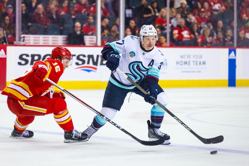 Mar 4, 2024; Calgary, Alberta, CAN; Seattle Kraken center Yanni Gourde (37) controls the puck against Calgary Flames left wing Dryden Hunt (15) during the first period at Scotiabank Saddledome. Mandatory Credit: Sergei Belski-USA TODAY Sports