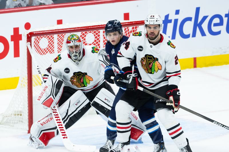 Jan 11, 2024; Winnipeg, Manitoba, CAN; Chicago Blackhawks forward Jaycob Megna (24) jostles for position with Winnipeg Jets forward Cole Perfetti (91) in front of Chicago Blackhawks goalie Petr Mrazek (34) during the third period at Canada Life Centre. Mandatory Credit: Terrence Lee-USA TODAY Sports