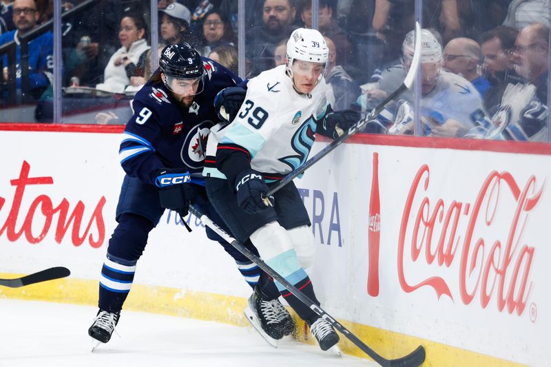 Apr 16, 2024; Winnipeg, Manitoba, CAN;  Winnipeg Jets forward Alex Iafallo (9) battles Seattle Kraken defenseman Ryker Evans (39) for the puck during the second period at Canada Life Centre. Mandatory Credit: Terrence Lee-USA TODAY Sports