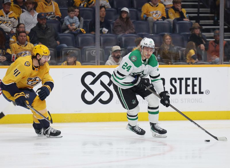 Nov 8, 2025; Nashville, Tennessee, USA; Dallas Stars center Roope Hintz (24) moves the puck as he is guarded by Nashville Predators defenseman Nicolas Hague (41) during the second period at Bridgestone Arena. Mandatory Credit: Alan Poizner-Imagn Images