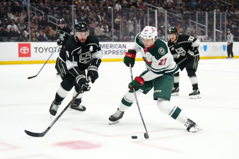 Apr 15, 2024; Los Angeles, California, USA; Minnesota Wild center Jacob Lucchini (27) shoots the puck against LA Kings defenseman Drew Doughty (8) in the first period at Crypto.com Arena. Mandatory Credit: Kirby Lee-USA TODAY Sports