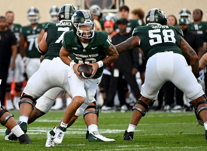 Sep 1, 2023; East Lansing, Michigan, USA;  Michigan State Spartans quarterback Noah Kim (10) rolls out with the football in the second quarter against the Central Michigan Chippewas at Spartan Stadium. Mandatory Credit: Dale Young-USA TODAY Sports