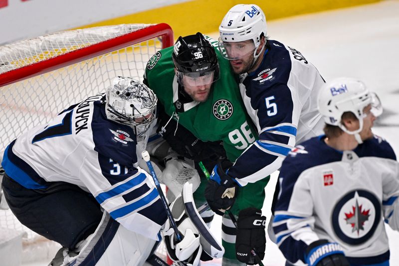 May 17, 2025; Dallas, Texas, USA; Winnipeg Jets goaltender Connor Hellebuyck (37) and defenseman Luke Schenn (5) and Dallas Stars right wing Mikko Rantanen (96) battle for position in the crease during the third period in game six of the second round of the 2025 Stanley Cup Playoffs at American Airlines Center. Mandatory Credit: Jerome Miron-Imagn Images
