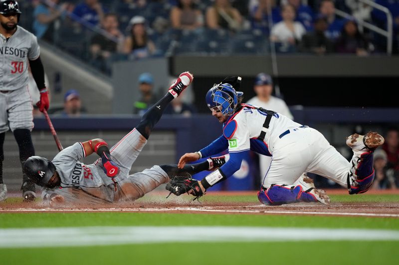 May 10, 2024; Toronto, Ontario, CAN; Toronto Blue Jays catcher Danny Jansen (9) tags out Minnesota Twins center fielder Willi Castro (50) trying to steal home during the first inning at Rogers Centre. Mandatory Credit: John E. Sokolowski-USA TODAY Sports