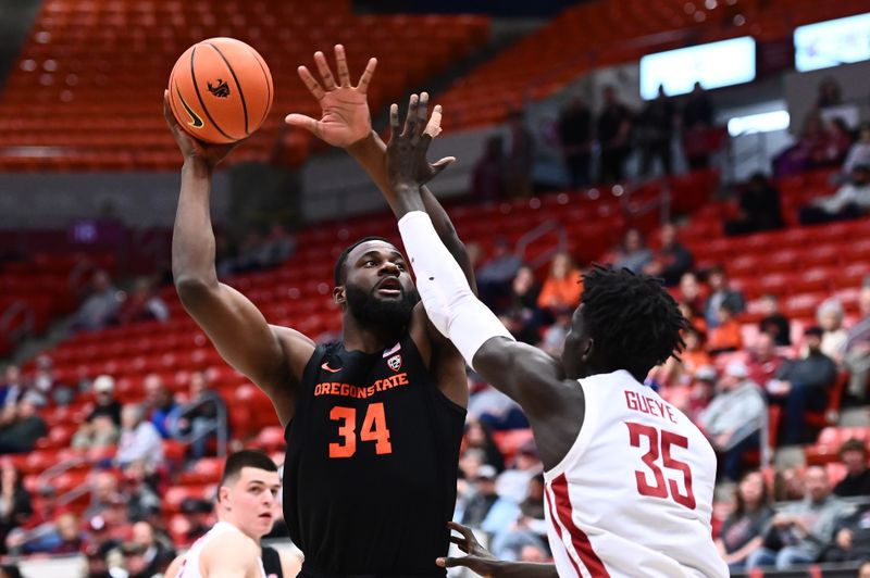 Feb 16, 2023; Pullman, Washington, USA; Oregon State Beavers forward Rodrigue Andela (34) shoots the ball against Washington State Cougars forward Mouhamed Gueye (35) in the first half at Friel Court at Beasley Coliseum. Mandatory Credit: James Snook-USA TODAY Sports