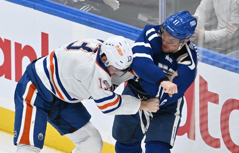 Mar 23, 2024; Toronto, Ontario, CAN; Toronto Maple Leafs forward Max Domi (11) fights with Edmonton Oilers forward Mattias Janmark (13) in the third period at Scotiabank Arena. Mandatory Credit: Dan Hamilton-USA TODAY Sports