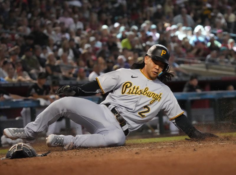 Jul 9, 2023; Phoenix, Arizona, USA; Pittsburgh Pirates Connor Joe (2) slides in safely at home plate to score a run against the Arizona Diamondbacks at Chase Field. Mandatory Credit: Joe Rondone-USA TODAY Sports