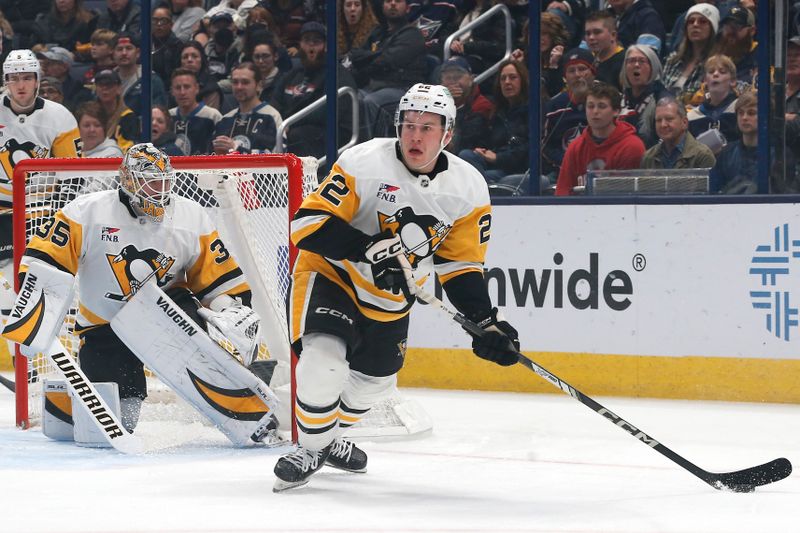 Nov 15, 2024; Columbus, Ohio, USA; Pittsburgh Penguins left wing Sam Poulin (22) picks up a loose puck against the Columbus Blue Jackets during the first period at Nationwide Arena. Mandatory Credit: Russell LaBounty-Imagn Images