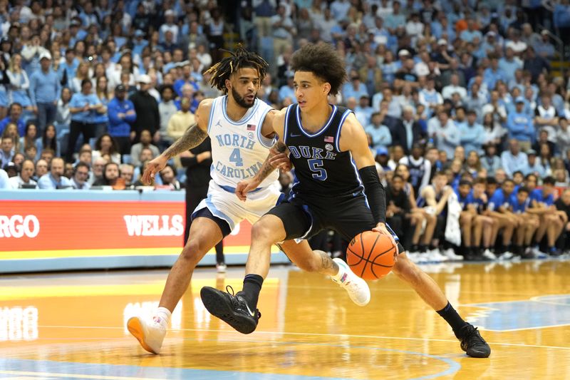 Mar 4, 2023; Chapel Hill, North Carolina, USA;  Duke Blue Devils guard Tyrese Proctor (5) dribbles as North Carolina Tar Heels guard R.J. Davis (4) defends in the first half at Dean E. Smith Center. Mandatory Credit: Bob Donnan-USA TODAY Sports