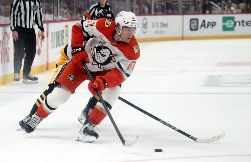 Oct 31, 2024; Pittsburgh, Pennsylvania, USA;  Anaheim Ducks left wing Cutter Gauthier (61) moves the puck ahead of Pittsburgh Penguins center Lars Eller (20) during the second period at PPG Paints Arena. Mandatory Credit: Charles LeClaire-Imagn Images