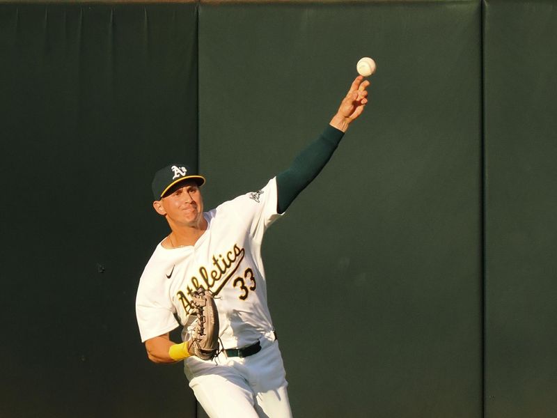 Jul 22, 2024; Oakland, California, USA; Oakland Athletics center fielder JJ Bleday (33) throws the ball infield against the Houston Astros during the first inning at Oakland-Alameda County Coliseum. Mandatory Credit: Kelley L Cox-USA TODAY Sports