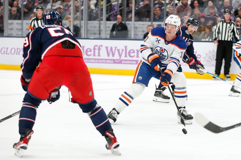 Nov 13, 2025; Columbus, Ohio, USA; Edmonton Oilers center Trent Frederic (10) passes against Columbus Blue Jackets right wing Yegor Chinakhov (59) during the first period at Nationwide Arena. Mandatory Credit: Russell LaBounty-Imagn Images