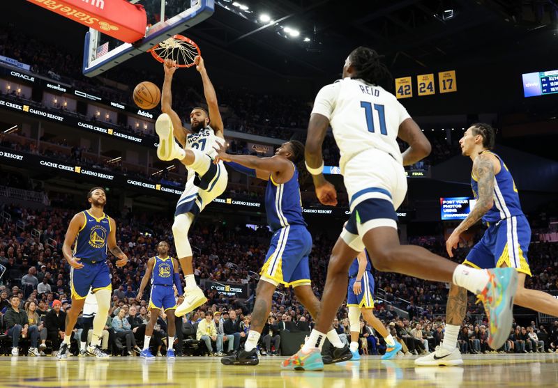 SAN FRANCISCO, CALIFORNIA - DECEMBER 06: Rudy Gobert #27 of the Minnesota Timberwolves dunks the ball on Kevon Looney #5 of the Golden State Warriors during the second half at Chase Center on December 06, 2024 in San Francisco, California. NOTE TO USER: User expressly acknowledges and agrees that, by downloading and/or using this photograph, user is consenting to the terms and conditions of the Getty Images License Agreement.   (Photo by Ezra Shaw/Getty Images)