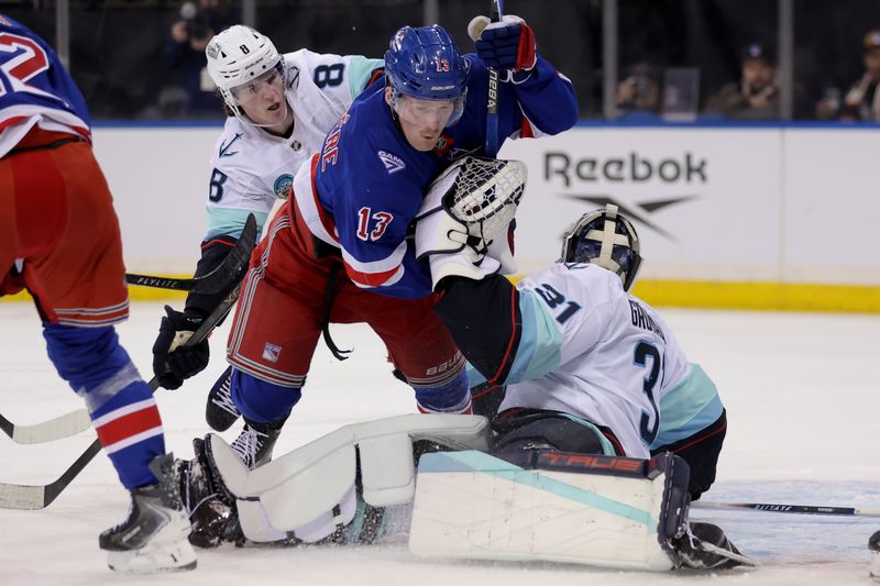Jan 12, 2026; New York, New York, USA; New York Rangers left wing Alexis Lafreniere (13) collides with Seattle Kraken goaltender Philipp Grubauer (31) and defenseman Cale Fleury (8) during the second period at Madison Square Garden. Mandatory Credit: Brad Penner-Imagn Images
