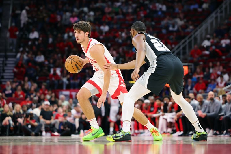 HOUSTON, TEXAS - OCTOBER 17: Reed Sheppard #15 of the Houston Rockets dribbles against Malaki Branham #22 of the San Antonio Spurs during the first half of a preseason game at Toyota Center on October 17, 2024 in Houston, Texas. NOTE TO USER: User expressly acknowledges and agrees that, by downloading and or using this photograph, User is consenting to the terms and conditions of the Getty Images License Agreement. (Photo by Alex Slitz/Getty Images)