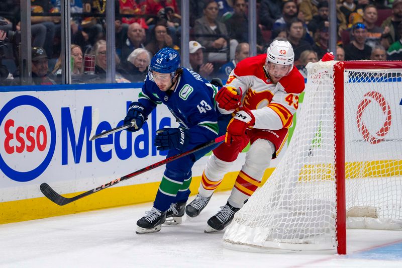 Oct 9, 2024; Vancouver, British Columbia, CAN; Vancouver Canucks defenseman Quinn Hughes (43) battles with Calgary Flames forward Adam Klapka (43) during the first period at Rogers Arena. Mandatory Credit: Bob Frid-Imagn Images