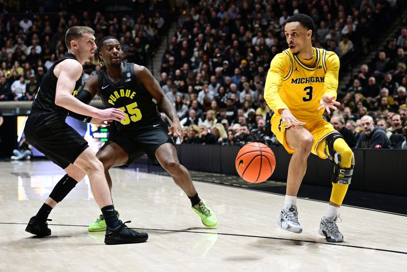 Jan 23, 2024; West Lafayette, Indiana, USA; Michigan Wolverines guard Jaelin Llewellyn (3) passes the ball around Purdue Boilermakers guard Braden Smith (3) and guard Lance Jones (55) during the first half at Mackey Arena. Mandatory Credit: Marc Lebryk-USA TODAY Sports