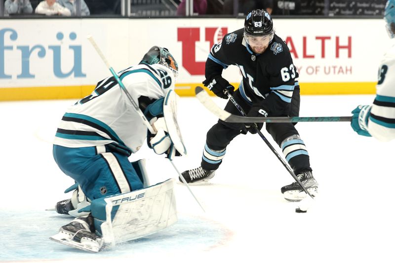 Oct 28, 2024; Salt Lake City, Utah, USA; Utah Hockey Club left wing Matias Maccelli (63) slides the puck past San Jose Sharks goaltender Mackenzie Blackwood (29) and into the net during the second period at Delta Center. Mandatory Credit: Chris Nicoll-Imagn Images