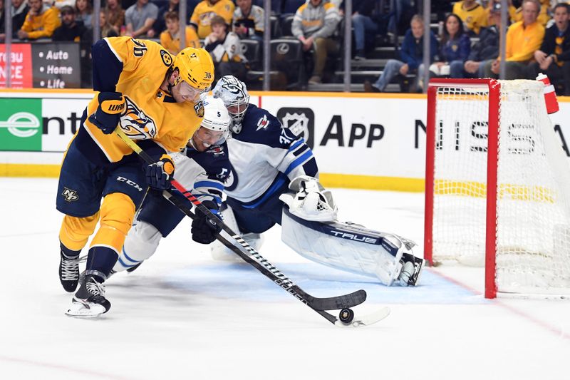 Apr 9, 2024; Nashville, Tennessee, USA; Nashville Predators left wing Cole Smith (36) has a shot blocked by Winnipeg Jets defenseman Brenden Dillon (5) during the third period at Bridgestone Arena. Mandatory Credit: Christopher Hanewinckel-USA TODAY Sports