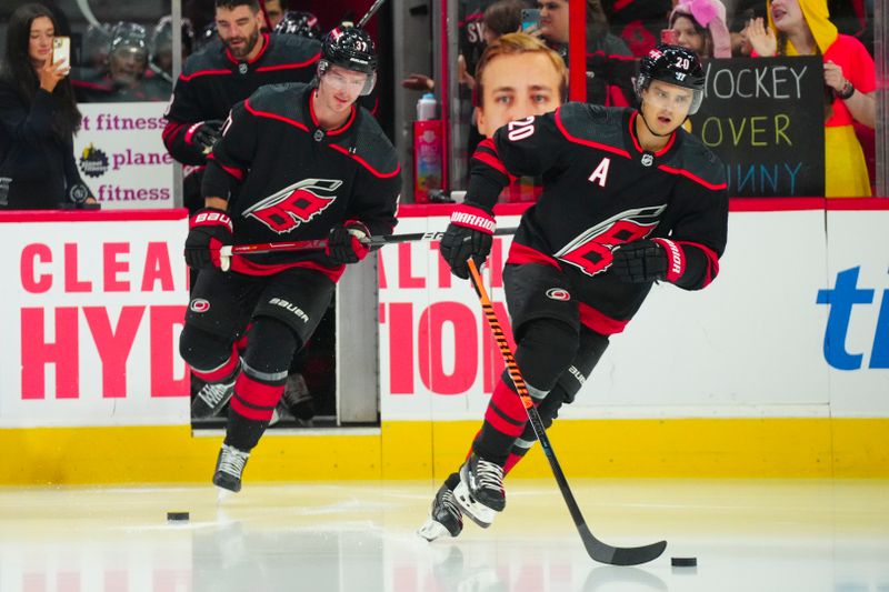 Oct 27, 2023; Raleigh, North Carolina, USA; Carolina Hurricanes center Sebastian Aho (20) and right wing Andrei Svechnikov (37) comes out onto the ice for the warmups before the game against the San Jose Sharks at PNC Arena. Mandatory Credit: James Guillory-USA TODAY Sports