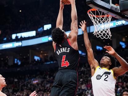 TORONTO, ON - DECEMBER 23: Scottie Barnes #4 of the Toronto Raptors dunks against Collin Sexton #2 of the Utah Jazz during the first half of their basketball game at the Scotiabank Arena on December 23, 2023 in Toronto, Ontario, Canada. NOTE TO USER: User expressly acknowledges and agrees that, by downloading and/or using this Photograph, user is consenting to the terms and conditions of the Getty Images License Agreement. (Photo by Mark Blinch/Getty Images)