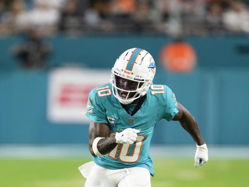 Miami Dolphins wide receiver Tyreek Hill (10) runs a play during an NFL football game against the Tennessee Titans, Monday, Dec. 12, 2023, in Miami Gardens, Fla. (AP Photo/Doug Murray)