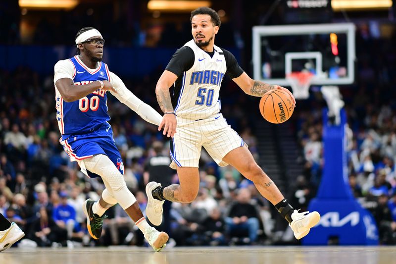 ORLANDO, FLORIDA - OCTOBER 18: Cole Anthony #50 of the Orlando Magic drives to the basket against Reggie Jackson #00 of the Philadelphia 76ers in the second half of a game at Kia Center on October 18, 2024 in Orlando, Florida. NOTE TO USER: User expressly acknowledges and agrees that, by downloading and or using this photograph, User is consenting to the terms and conditions of the Getty Images License Agreement. (Photo by Julio Aguilar/Getty Images)