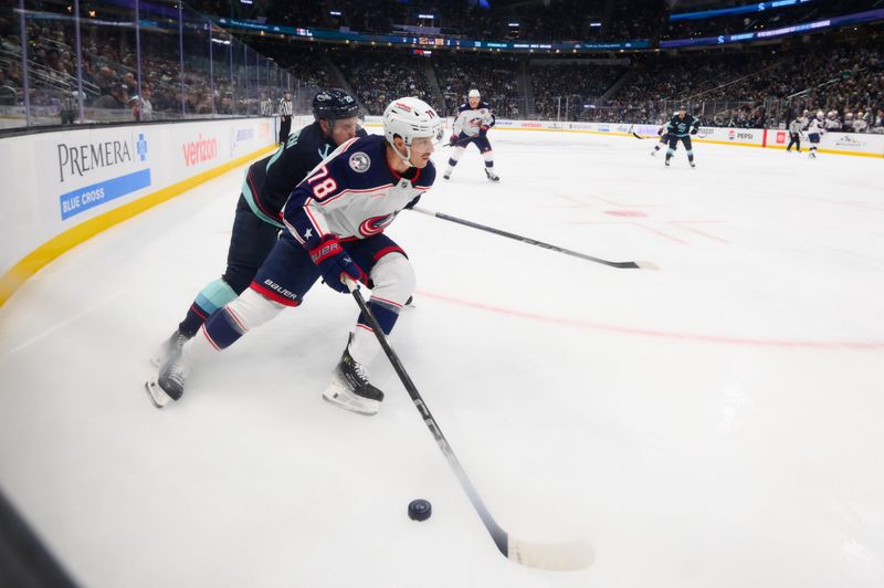 Nov 12, 2024; Seattle, Washington, USA; Columbus Blue Jackets defenseman Damon Severson (78) plays the puck while defended by Seattle Kraken right wing Eeli Tolvanen (20)  during the second period at Climate Pledge Arena. Mandatory Credit: Steven Bisig-Imagn Images