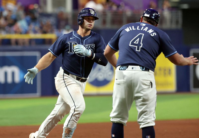 Jun 25, 2024; St. Petersburg, Florida, USA;Tampa Bay Rays catcher Ben Rortvedt (30) is congratulated by third base coach Brady Williams (4) after he hit a 2-run home run against the Seattle Mariners during the sixth inning  at Tropicana Field. Mandatory Credit: Kim Klement Neitzel-USA TODAY Sports