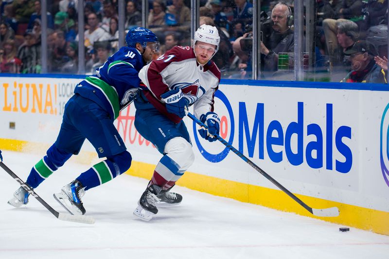 Mar 13, 2024; Vancouver, British Columbia, CAN; Vancouver Canucks forward Elias Pettersson (40) checks Colorado Avalanche forward Casey Mittelstadt (37) in the first period at Rogers Arena. Mandatory Credit: Bob Frid-USA TODAY Sports