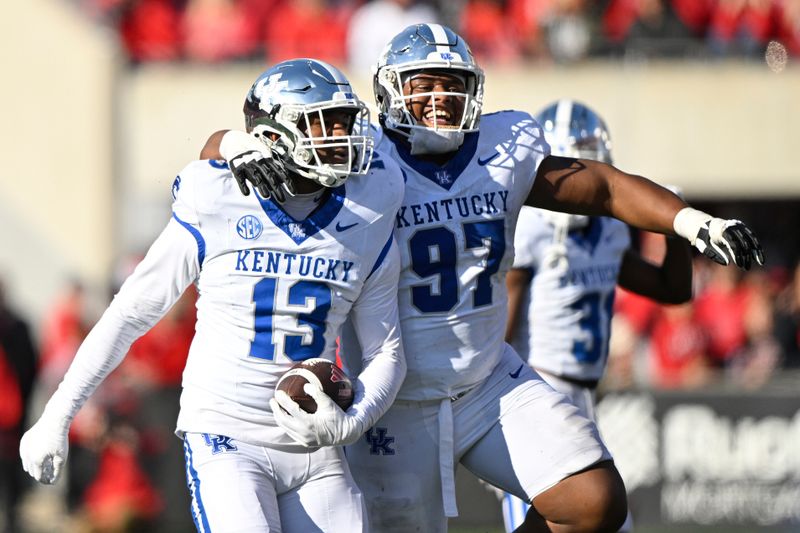 Nov 25, 2023; Louisville, Kentucky, USA;  Kentucky Wildcats linebacker J.J. Weaver (13) celebrates a fumble recovery with defensive lineman Josaih Hayes (97) during the second half against the Louisville Cardinals at L&N Federal Credit Union Stadium. Kentucky defeated Louisville 38-31. Mandatory Credit: Jamie Rhodes-USA TODAY Sports