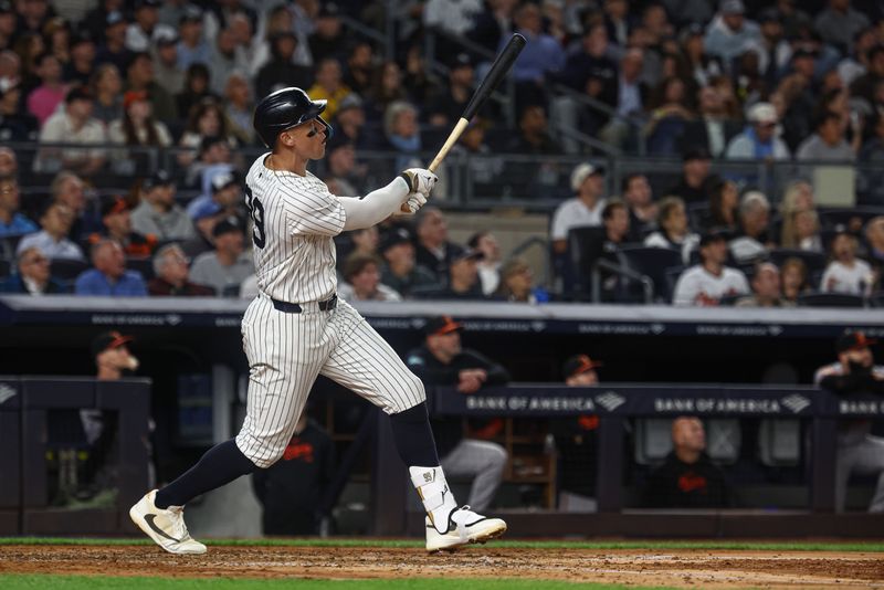 Sep 24, 2024; Bronx, New York, USA; New York Yankees center fielder Aaron Judge (99) hits a solo home run during the fourth inning against the Baltimore Orioles at Yankee Stadium. Mandatory Credit: Vincent Carchietta-Imagn Images