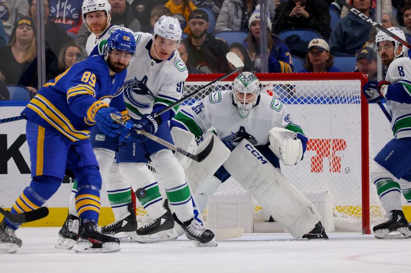 Jan 13, 2024; Buffalo, New York, USA;  Buffalo Sabres right wing Alex Tuch (89) looks to deflect a shot on Vancouver Canucks goaltender Thatcher Demko (35) during the first period at KeyBank Center. Mandatory Credit: Timothy T. Ludwig-USA TODAY Sports