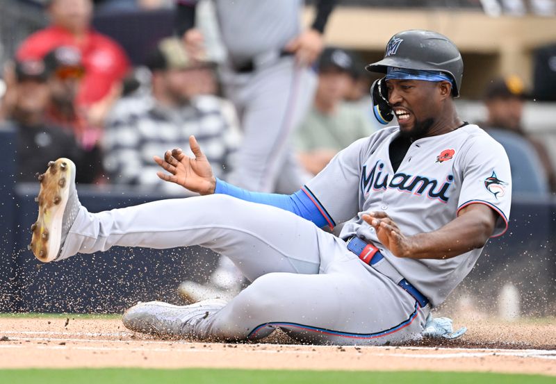 May 26, 2025; San Diego, California, USA; Miami Marlins right fielder Jesus Sanchez (7) slides as he scores during the first inning against the San Diego Padres at Petco Park. Mandatory Credit: Denis Poroy-Imagn Images