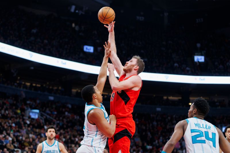 TORONTO, CANADA - MARCH 3: Jakob Poeltl #19 of the Toronto Raptors puts up a shot over Grant Williams #2 of the Charlotte Hornets in the first half of their NBA game at Scotiabank Arena on March 3, 2024 in Toronto, Canada. NOTE TO USER: User expressly acknowledges and agrees that, by downloading and or using this photograph, User is consenting to the terms and conditions of the Getty Images License Agreement. (Photo by Cole Burston/Getty Images)