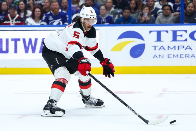 Nov 16, 2024; Tampa, Florida, USA; New Jersey Devils defenseman Brenden Dillon (5) controls the puck against the Tampa Bay Lightning in the first period at Amalie Arena. Mandatory Credit: Nathan Ray Seebeck-Imagn Images