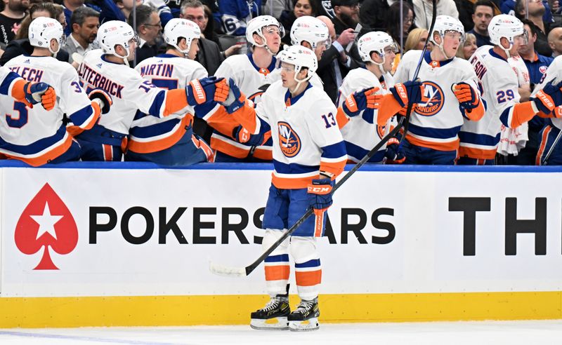 Feb 5, 2024; Toronto, Ontario, CAN;  New York Islanders forward Mathew Barzal (13) celebrates with team mates at the bench after scoring against the Toronto Maple Leafs int he first period at Scotiabank Arena. Mandatory Credit: Dan Hamilton-USA TODAY Sports