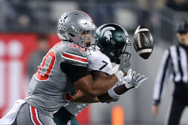 Nov 11, 2023; Columbus, Ohio, USA; Ohio State Buckeyes linebacker Cody Simon (30) breaks up the pass intended for Michigan State Spartans wide receiver Antonio Gates Jr. (7) during the third quarter at Ohio Stadium. Mandatory Credit: Joseph Maiorana-USA TODAY Sports