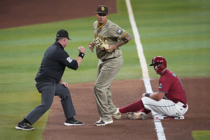 Aug 6, 2025; Phoenix, Arizona, USA; San Diego Padres third base Manny Machado (13) reacts after tagging out Arizona Diamondbacks catcher James McCann (8) at third base during the seventh inning at Chase Field. Mandatory Credit: Joe Camporeale-Imagn Images
