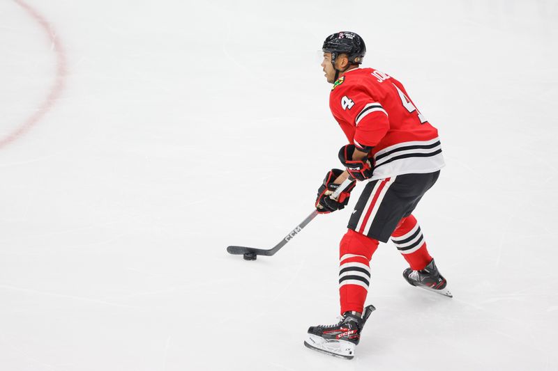 Mar 26, 2024; Chicago, Illinois, USA; Chicago Blackhawks defenseman Seth Jones (4) looks to shoot against the Calgary Flames during the first period at United Center. Mandatory Credit: Kamil Krzaczynski-USA TODAY Sports